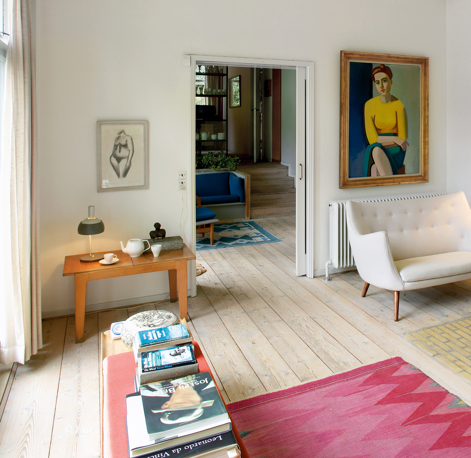 A cozy living room with minimalist design and a lamp, © 2025 Louis Poulsen.