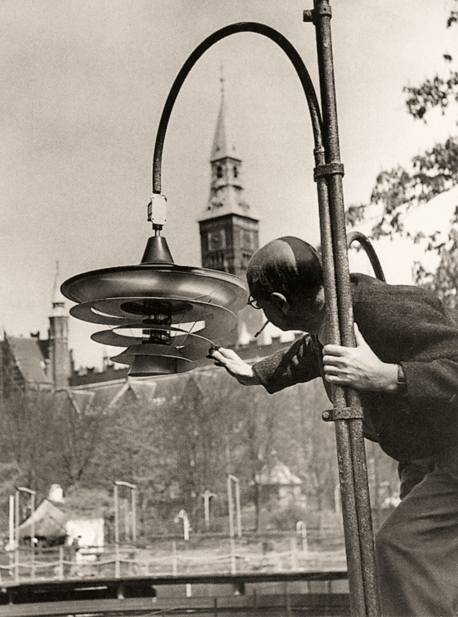 Poul Henningsen inspecting early outdoor lamp fixture in Copenhagen, © 2025 Louis Poulsen.